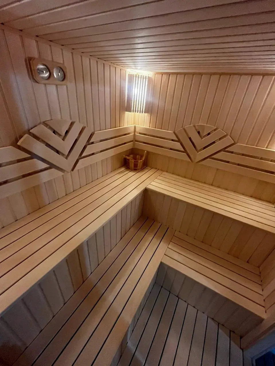 Cökə ağacından daxili sauna: iki pilləli L formalı oturacaqlar, baş dayaqları və gizli işıq